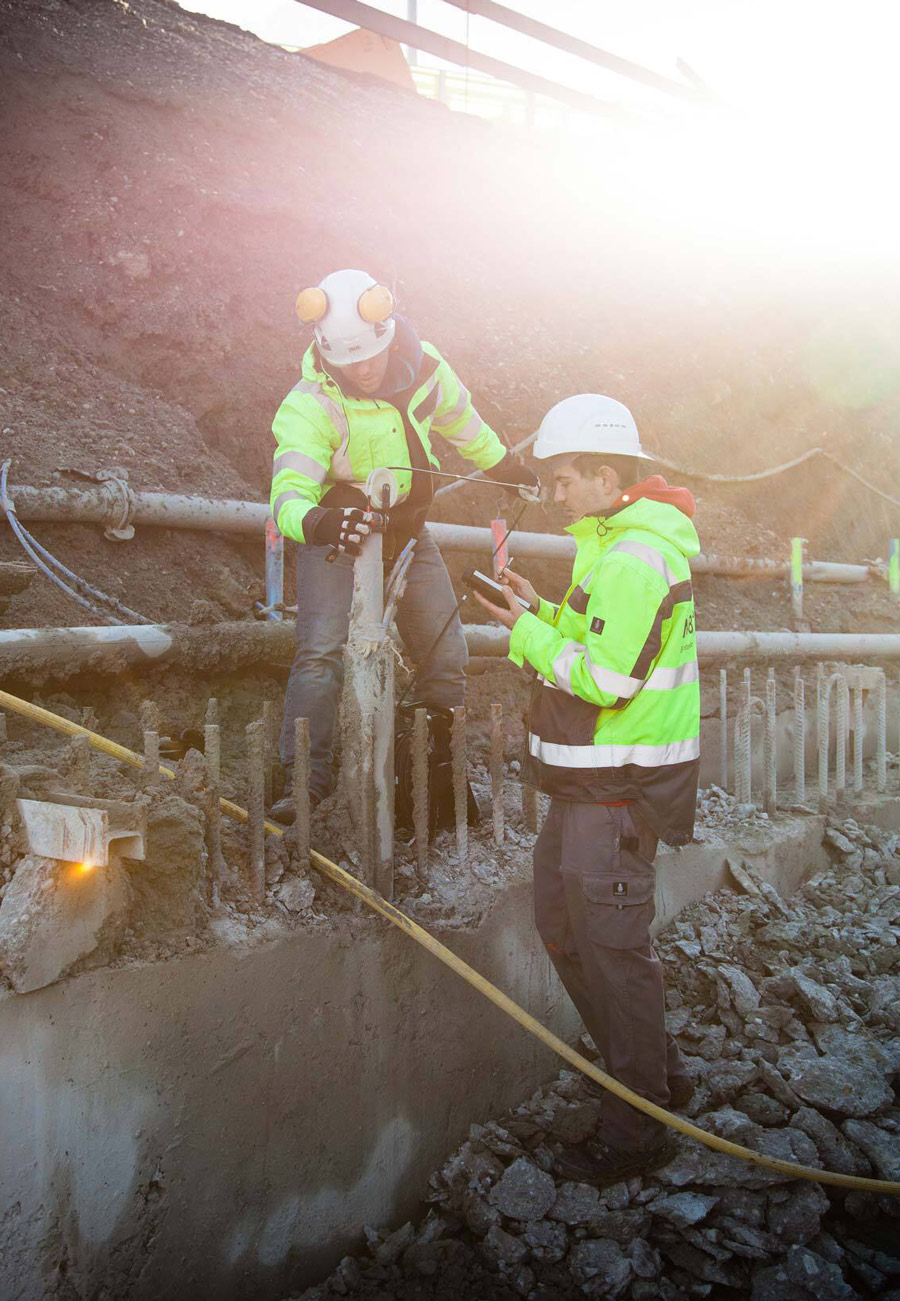 Zwei Mitarbeiter von Bogensberger mit einem Inklinometer auf einer Baustelle