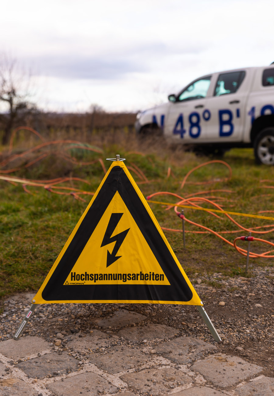 Ein Hinweisschild am Boden für Hochspannungsarbeiten