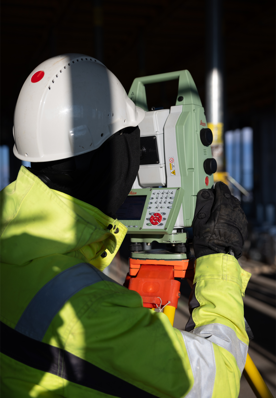 Ein Mitarbeiter von Bogensberger Vermessung mit Totalstation