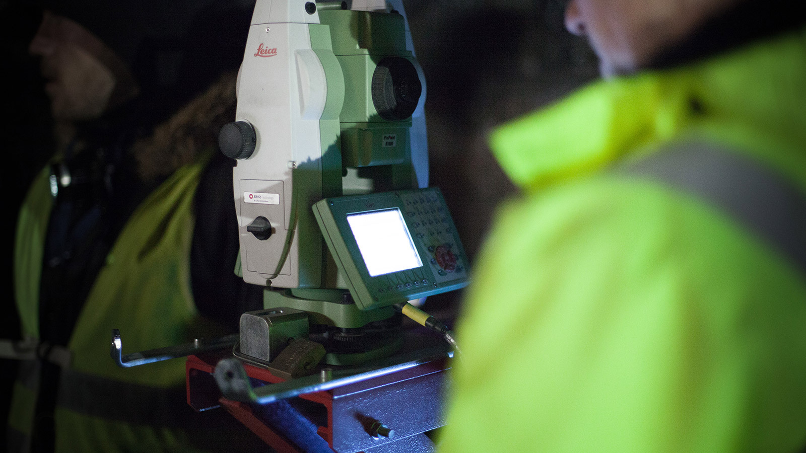 Ein Mitarbeiter von Bogensberger mit Totalstation bei Vermessungsarbeiten in einem Tunnel